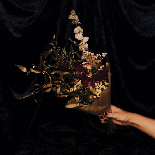 Bouquet of dried flowers held against a dark background