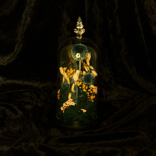 Decorative glass dome with floral arrangement on a dark background